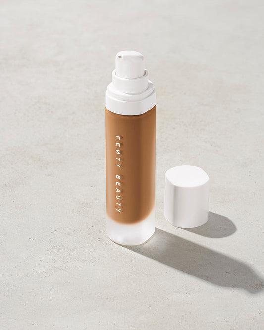 open bottle of Fenty Beauty Pro Filt'r Soft Matte Longwear Foundation with pump dispenser in shade 385 on concrete background
