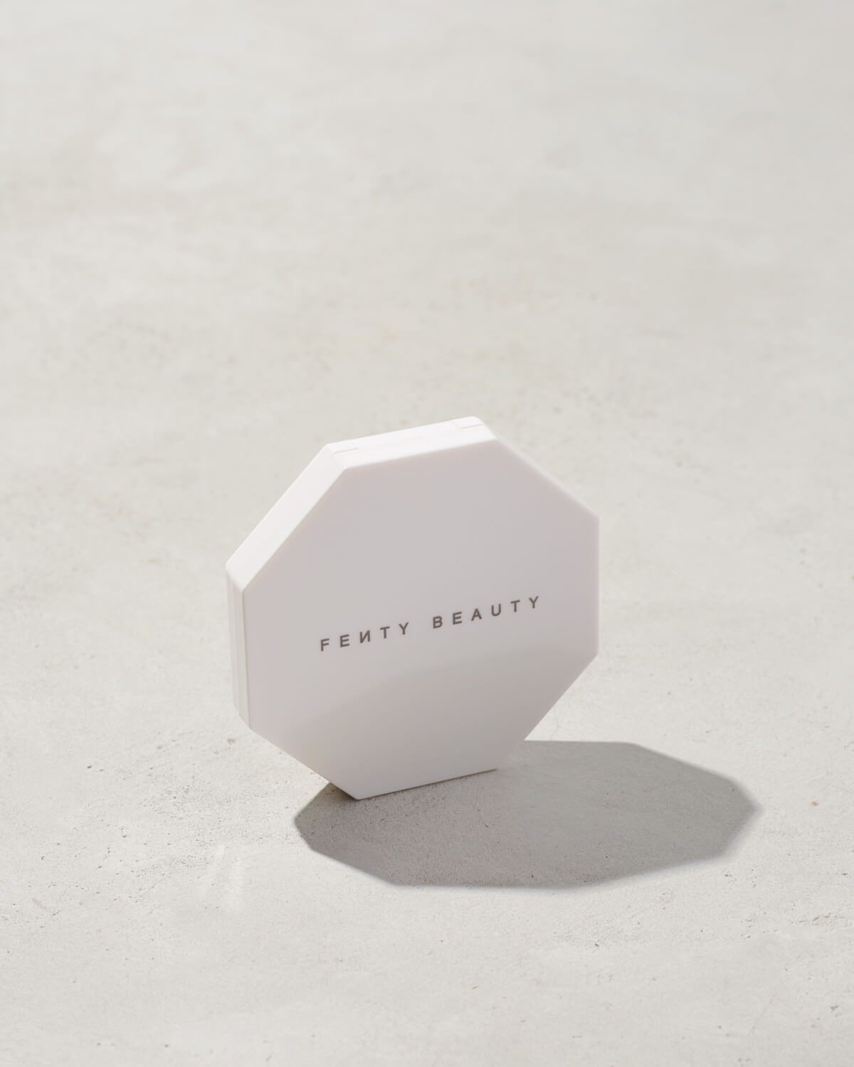 imagery of the white outside packaging imagery of killawatt freestyle highlighter in shade lightning dust/fire crystal on a concrete background