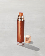 Open product shot of Body Lava Body Luminizer in shade 'Penny Drop'.