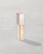 Gloss Bomb Oil Luminizing Oil and Gloss in shade Supafine Suga product against a concrete background.