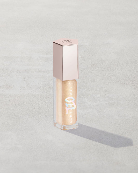 Gloss Bomb Oil Luminizing Oil and Gloss in shade Supafine Suga product against a concrete background.