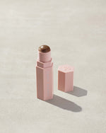 Opened Match Stix Contour Skinstick in the shade Suedish container on a grey background.