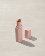 Match Stix Shimmer Skinstick shown in shade Truffle Spark on a concrete background.