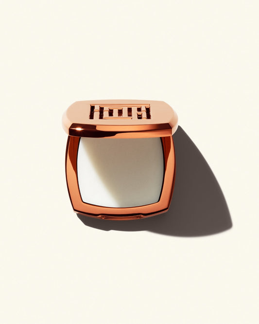 Open shot of Fenty Fragrance Solid Parfum on a cream background