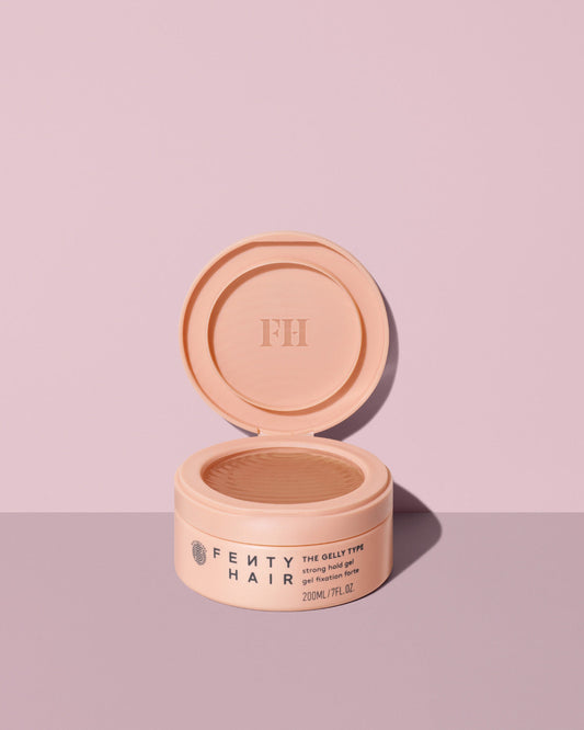 Fenty Hair The Gelly Type Strong Hold Gel tub open on a lavender background.